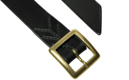 Detail of the buckle and tail of the black vegetable tanned leather belt with a square buckle in raw brass, hand-sewn with waxed linen thread